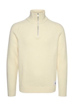 Kreemikaalane, soonitud kootud pullover-sweater kõrge kaelusega ja lühikese lukuga. Omab pikki varrukaid ja külge sildiga number "73."