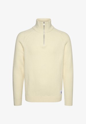 Kreemikaalane, soonitud kootud pullover-sweater kõrge kaelusega ja lühikese lukuga. Omab pikki varrukaid ja külge sildiga number "73."