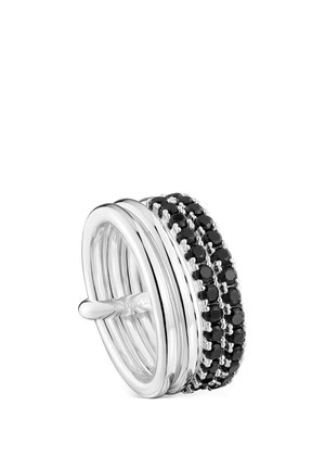 Anillo de plata con cuatro bandas lisas y tres filas de pequeñas piedras negras redondas dispuestas en una fila, mostrado sobre un fondo blanco.