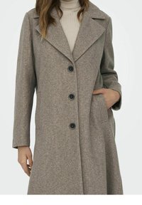 Abrigo de mezcla de lana gris con solapas en pico, cinco botones y bolsillos laterales. Presenta un corte relajado y una textura suave.