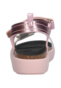 Zijaanzicht van een roze sandaal met metallic banden, een gestructureerde zwarte voetbed en een lichtroze kurkachtige zool.