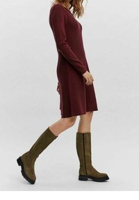 Burgunderfärgad långärmad klänning med rak skärning, i kombination med knähöga olivgröna stövlar med texturerad yta och svarta sålar.