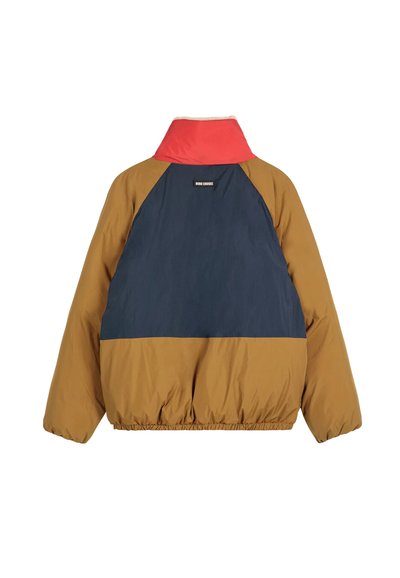 Giacca a blocchi di colore con colletto rosso, spalle blu navy e corpo marrone. Dotata di vita elastica e etichetta sul retro.