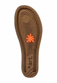 Suela de zapato de goma marrón con un patrón texturizado, que presenta un logo en forma de asterisco naranja en el centro. Bordes curvados y surcos de perfil profundo.