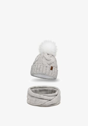 Világosszürke kötött sapka fehér műszőrme pom-pommal és fonott mintázattal, párosítva egy azonos árnyalatú szürke infinity sállal, amely texturált felülettel rendelkezik.