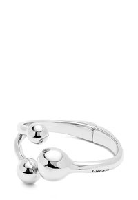 Pulsera en tono plateado con un acabado liso, que presenta un diseño flexible y dos acentos esféricos, mostrando una estética minimalista.