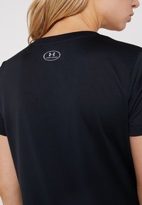 Zwart sport T-shirt met korte mouwen, een gladde textuur en een klein wit "Under Armour" logo bij de achterkant van de nek.