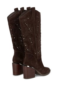 Botas de vaquero de ante marrón oscuro con tacones apilados de altura media y tachuelas plateadas decorativas a lo largo del cañón.