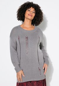 Grauer Strickpullover mit weitem Ausschnitt, der vertikale Ausschnitte, gerippte Bündchen und einen strukturierten Stoff aufweist. Auffällige rote Akzente sind in den Mustern sichtbar.