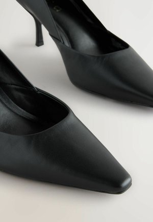 Čierne lodičky s jemne špicatou špičkou vyrobené z hladkej kože, s elegantným dizajnom a úzkym ihlovým opätkom. Bez viditeľných ozdôb.