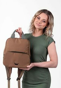 Hnědý látkový batoh s přední kapsou na zip, vzorovanými uchy a nastavitelnými popruhy, s logem na přední straně.
