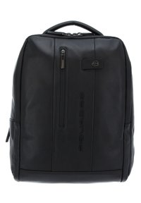 Mochila de cuero negro con un diseño estructurado, que presenta un asa superior, un bolsillo frontal con cremallera y un detalle de logo en relieve. Textura suave.