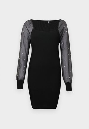 Abito bodycon nero a coste con maniche lunghe trasparenti decorate con piccole perle e polsini aderenti.
