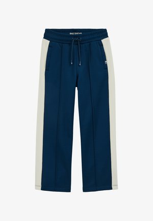 Granatowe spodnie z kremowymi panelami po bokach, elastyczną talią ze sznurkiem, przednimi kieszeniami oraz metką "Bad Boys" na talii i boku.