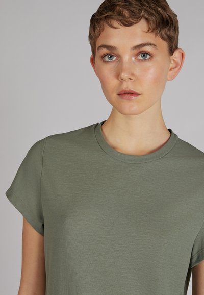 Oliwkowa koszulka z krótkim rękawem, wykonana z miękkiego, gładkiego materiału, z klasycznym okrągłym dekoltem i dopasowanym krojem.