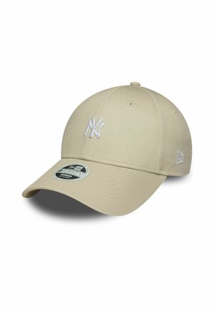Khaki baseball cap with a rounded crown, embroidered white New York Yankees logo, and a curved brim. Features a sticker on the brim.