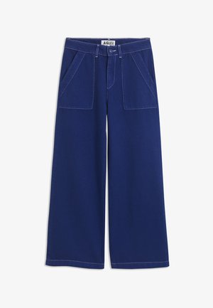 Donkerblauwe wijde broek met opgestikte voren zakken, riemlussen, knoopsluiting en zichtbare witte stiksels op een witte achtergrond.