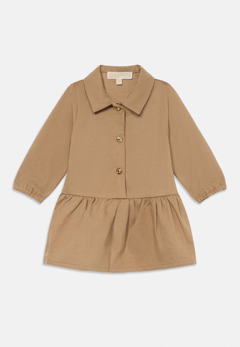 Vestido de menina de mangas compridas em tom de bege, com colarinho, fecho de botões na frente, saia ondeada e discretas bolinhas prateadas espalhadas pelo tecido.