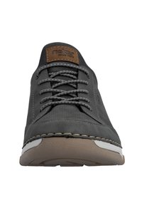 Chaussure grise à lacets avec une tige texturée et des accents lisses, dotée d'une étiquette en cuir marron et d'une semelle contrastante blanche et beige.
