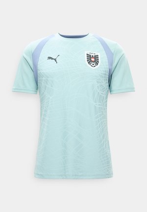 Maillot de sport bleu clair à manches courtes avec accents bleu foncé, motif en filet subtil, logo Puma sur la poitrine droite et écusson de l'équipe de football d'Autriche sur la gauche.