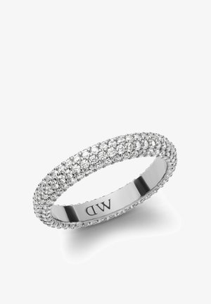 Strieborný prsteň s plnou bandou malých priehľadných kryštálov, vystavujúci textúrovaný povrch a hladký vnútorný prsteň s vygravírovanými iniciálami značky.