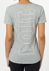 Camiseta de manga corta gris con gran texto blanco que dice "doit" en la parte de atrás. Fabricada en una tela suave y ligera, con un escote redondeado.