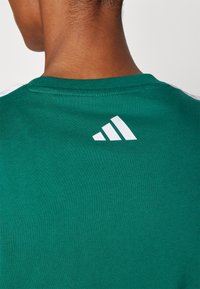 adidas Sportswear LOUNGE SOFT SIDE GRAPHIC - Marškinėliai su spaudiniu - collegiate green