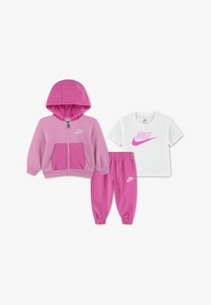 Ensemble Nike trois pièces pour enfants avec sweat à capuche rose, pantalon de jogging assorti rose et t-shirt blanc avec logo Nike rose.