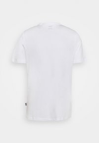 T-shirt blanc uni à manches courtes, vu de dos avec une petite étiquette de marque noire sur le côté gauche près de l'ourlet.