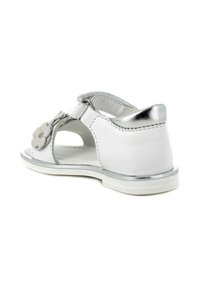 Sandal in pelle bianca con dettagli in argento e decori floreali, design aperto, suola piatta e cinturino posteriore per una vestibilità sicura.