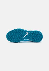 Nike Fußballschuh mit einer strukturierten Gummisohle in hellem Blau, ausgestattet mit einem weißen Nike-Swoosh. Entwickelt für Traktion auf Rasenflächen.