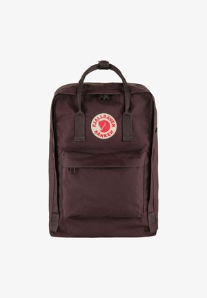 Sac à dos Fjällräven Kanken marron foncé en tissu durable, arborant un logo circulaire bien visible, avec deux anses supérieures et une poche frontale.