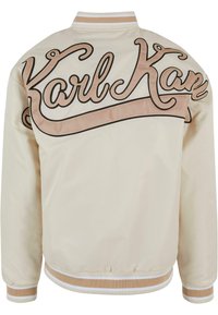 Hellbeige Bomberjacke mit weicher Textur. Verfügt über ein großes, braunes und beiges gesticktes "Karl Kan"-Logo auf dem Rücken und gerippte Ärmelsäume.