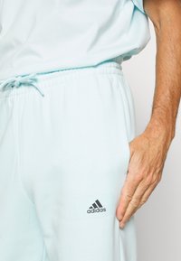 adidas Performance ESSENTIALS FEELVIVID FLEECE STRAIGHT - Jogginghose - blue
