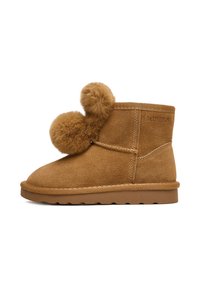Brązowy zamszowy botek za kostkę z dwoma dużymi pomponami z sztucznego futra po boku, płaska gumowa podeszwa oraz przeszycia wokół krawędzi.