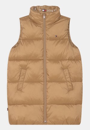 Beżowa, bezrękawnikowa kamizelka puchowa z kołnierzem stojącym, przednim zamkiem, bocznymi kieszeniami oraz małym logo Tommy Hilfiger na piersi i podszewce kołnierza.