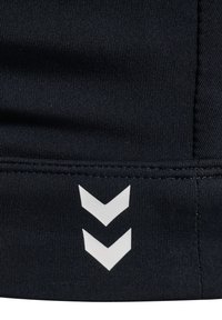 Marinsporttyg med strukturerad ribbning och vita chevron-accenter längs den nedre fållen. Sömdetaljer ger struktur.