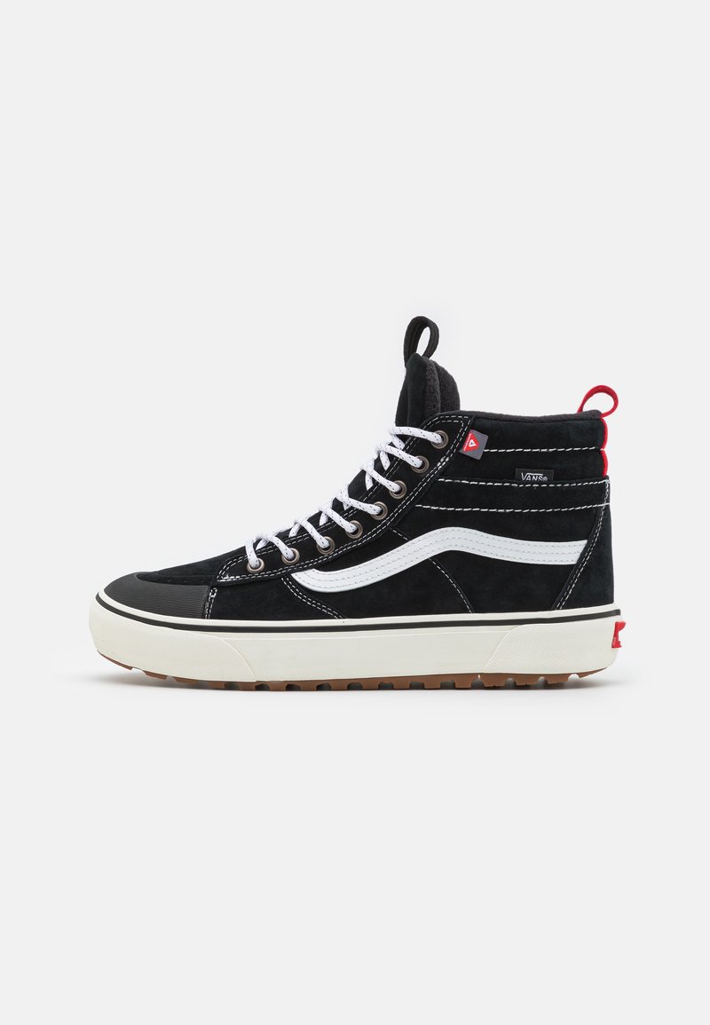 Svarte høyhælte sneakers laget av semsket skinn og gummi. Har en hvit stripe, polstret krage og rød hælflik. Hvite snører og teksturert såle.