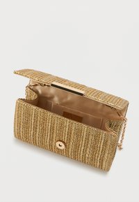 Kuldne kudumiga käekott tekstuuriga välispinnaga, magnetluku sulgemisega, ketilööniga ja beeži sametise sisepinnaga, kus on kaardipesa.