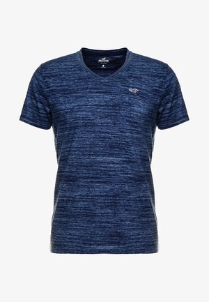 T-shirt bleu marine à manches courtes avec col en V, fabriqué à partir d'un tissu texturé à motif chiné ; présente un petit logo sur la poitrine.