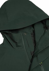 Grön vattentät jacka med huva, som har en dragkedja fram, texturerad tyg och justerbar dragsko. Synlig logotyp på huvan.