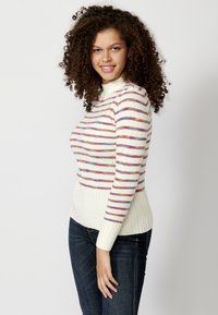 Maglione a righe con collo alto, caratterizzato da linee orizzontali in rosso, blu e viola su sfondo crema; polsini e orlo a coste.