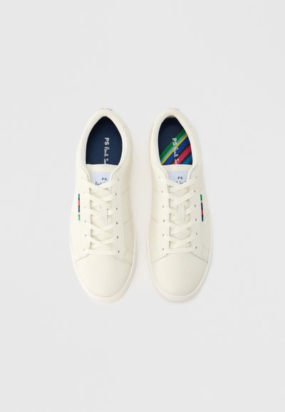 Biele kožené tenisky s textúrovaným povrchom, plochými šnúrkami a farebným pruhom na boku. Vo vnútri modrý a pruhovaný vzor.