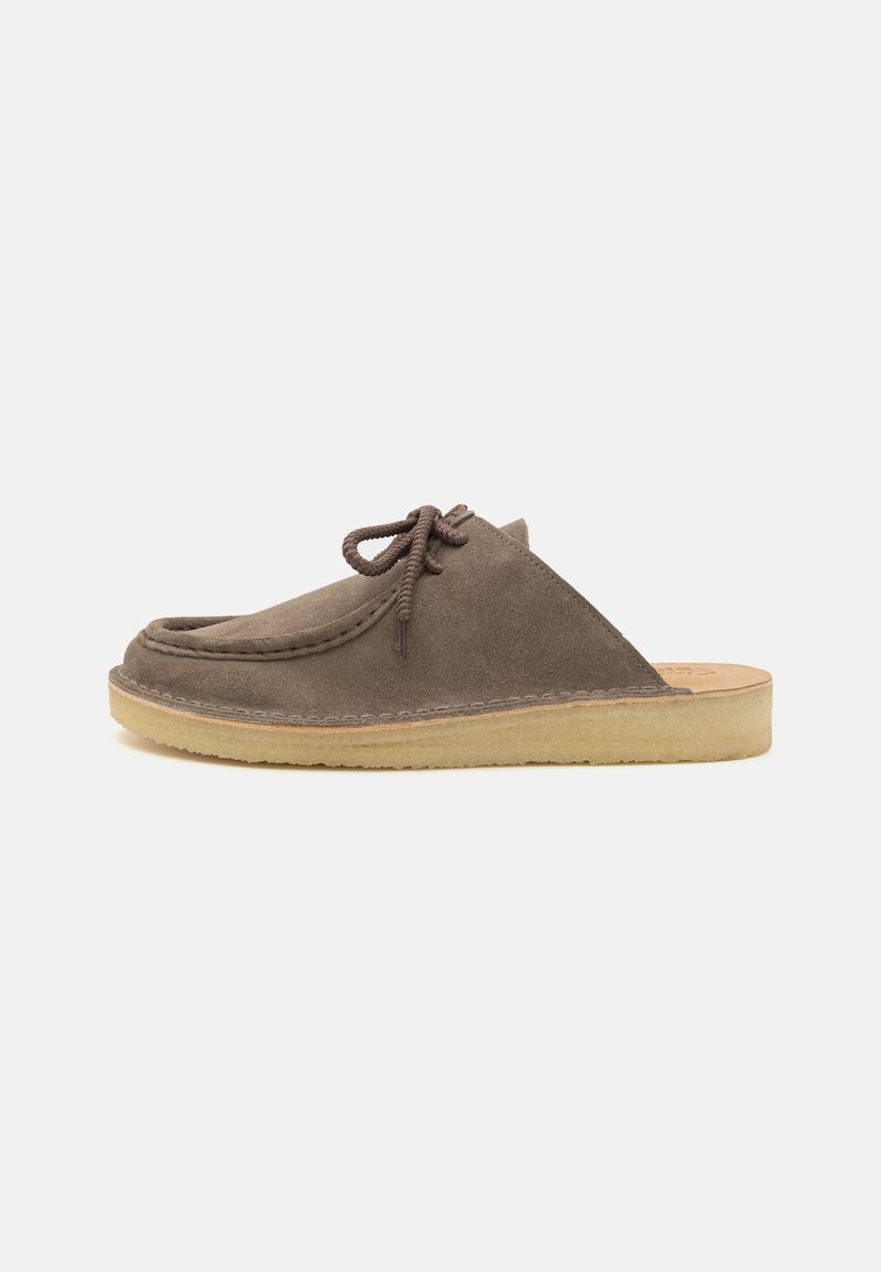 Brown suede slip-on shoes with a rounded toe, stitched detailing, and a light rubber sole. Features laces for a secure fit.