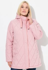 Chaqueta acolchada rosa con capucha, que cuenta con un cierre frontal, cordones y costuras diagonales. Textura suave con bolsillos laterales.