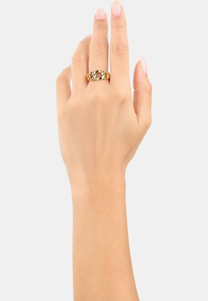 Anillo en tono dorado que presenta enlaces de cadena entrelazados sobre una banda lisa. El diseño tiene un acabado pulido y una apariencia ligera.
