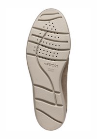 Suela de zapato de goma beige con patrones texturizados, orificios de ventilación y logotipo de la marca. Acabado suave y diseño curvado para mejorar la agarre.