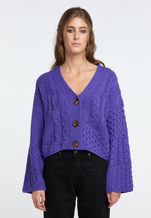 Lila gestrickte Cropped-Cardigan mit V-Ausschnitt, strukturierten Mustern und drei braunen Knöpfen an der Vorderseite. Weite Ärmel runden das Design ab.