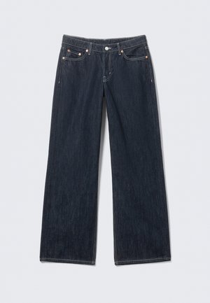 Jean denim à jambe large bleu foncé avec un design classique à cinq poches et des rivets en cuivre, avec des bas droits non ourlés.