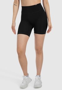 Pantaloni sportivi neri a vita alta realizzati in materiale elasticizzato, con una texture liscia e lunghezza fino a metà coscia per comfort e flessibilità.